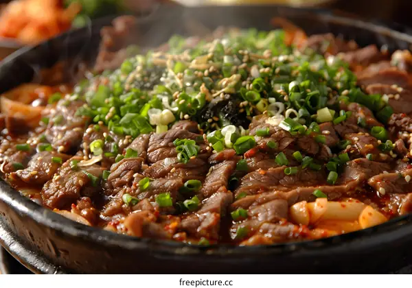 A sizzling plate of Korean bulgogi with kimchi and other korean side dishes