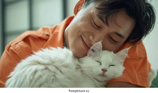 A young man is hugging a white cat