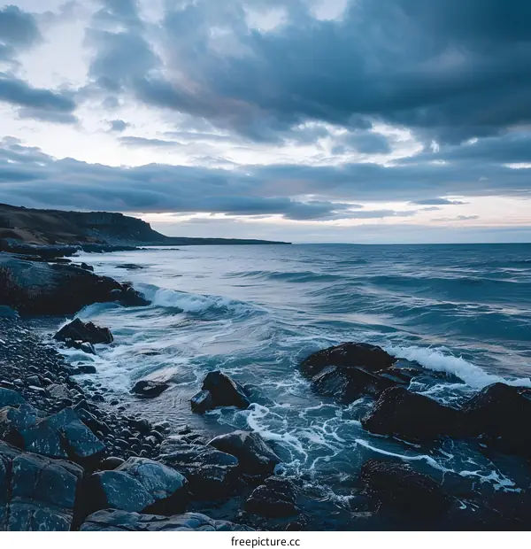 Waves Crashing on Rocky Coastline Under Cloudy Sky