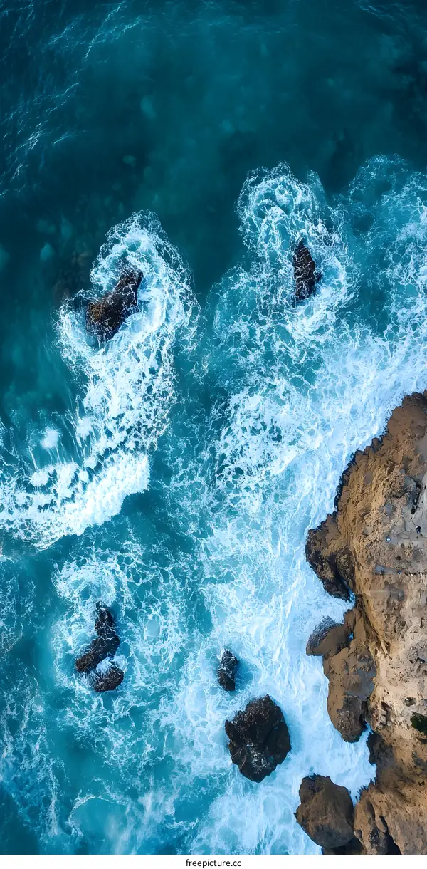Aerial View of Ocean Waves Crashing on Rocks