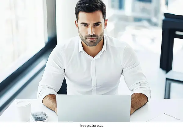 Focused Businessman Working on Laptop in Modern Office