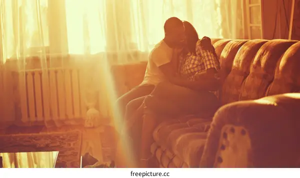 Young couple sitting on couch and embracing