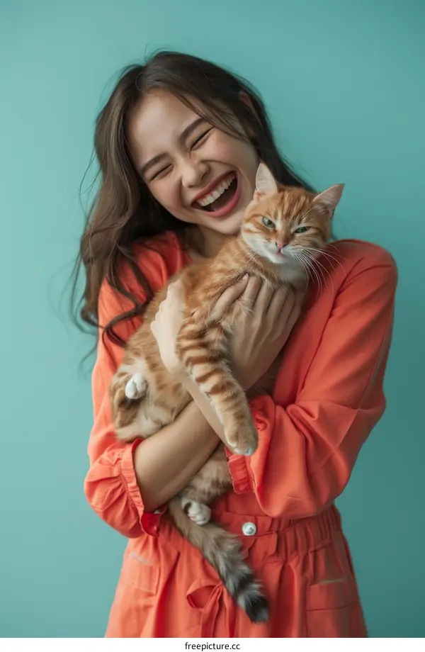 Laughing woman holding an orange cat