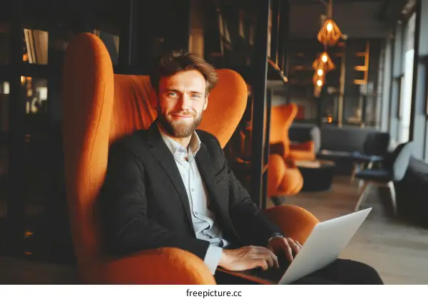 Caucasian Businessman Working on Laptop in Modern Lounge