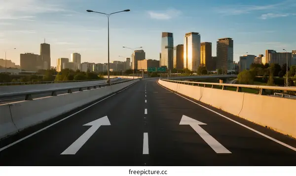 Urban highway with two arrows leading to city skyline under clear sky