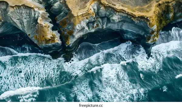Aerial View of Ocean Waves Crashing Against Rocky Coast