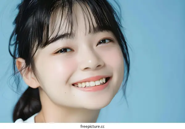 Smiling Asian Woman Portrait with Blue Background