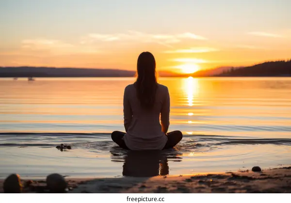 Woman Meditating In Lake At Sunset