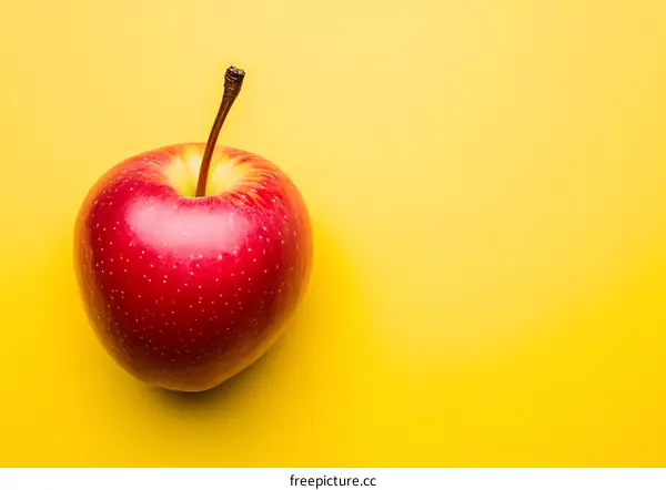 Red Apple on a Yellow Background