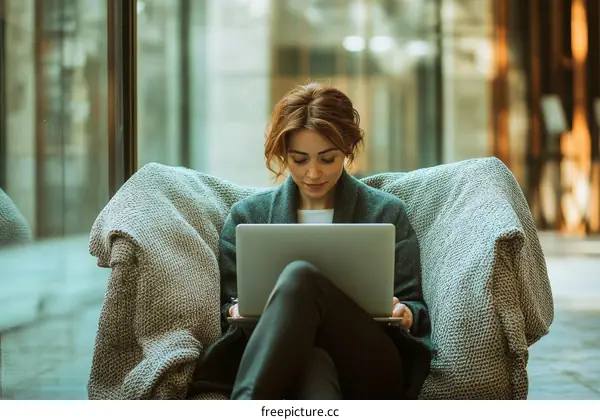 Woman Working on Laptop in Outdoor Cafe Setting