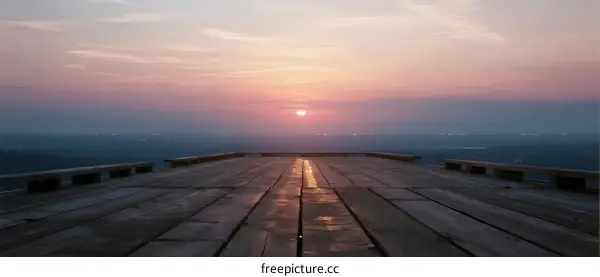 Sunset over a wooden platform with a serene view