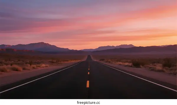 A Long Empty Road Stretching Under a Colorful Sunset Sky