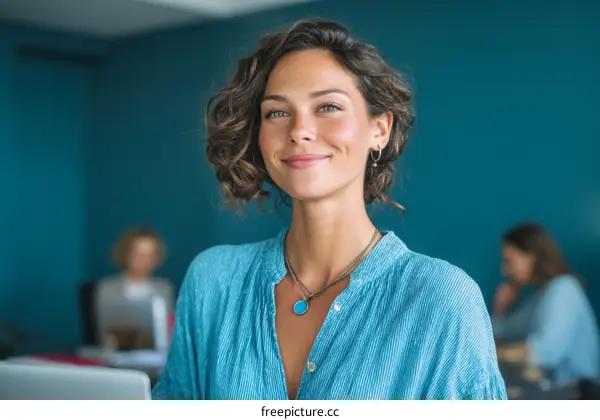 Confident young businesswoman in casual blue shirt at modern office