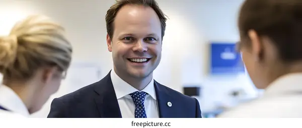 Smiling Businessman Talking To Colleagues