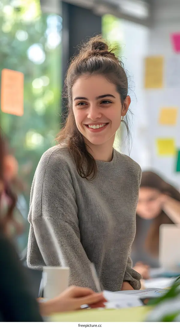 Smiling Woman With Bun Wearing Grey Sweater