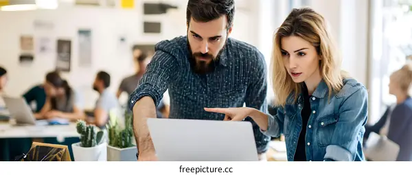 Two Businesspeople Collaborating and Discussing on Laptop