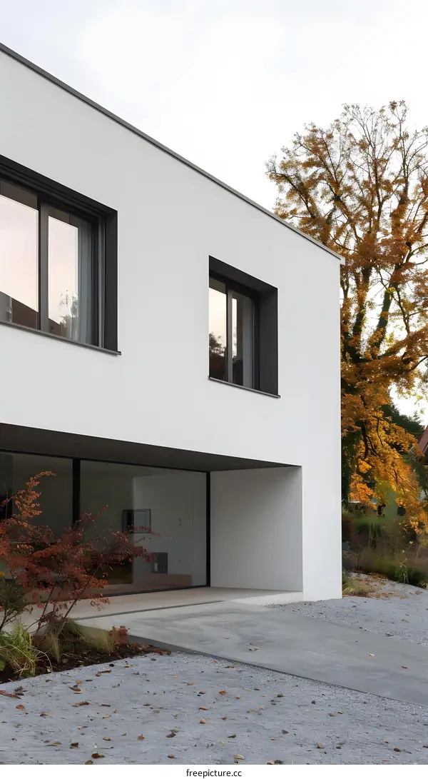 Modern White House Exterior With Large Windows And Gravel Driveway