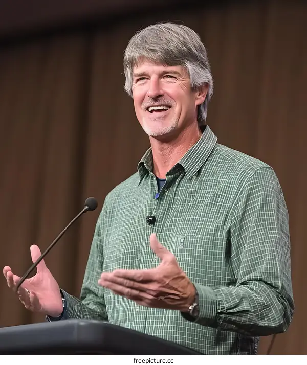 Smiling Man Giving a Speech on a Stage