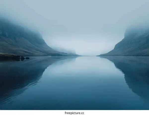 Misty Fjord Landscape: Dramatic Cliffs and Calm Waters