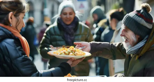 A group of volunteers serve food to the homeless on the street.