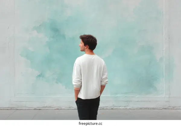 Man standing in front of a teal wall