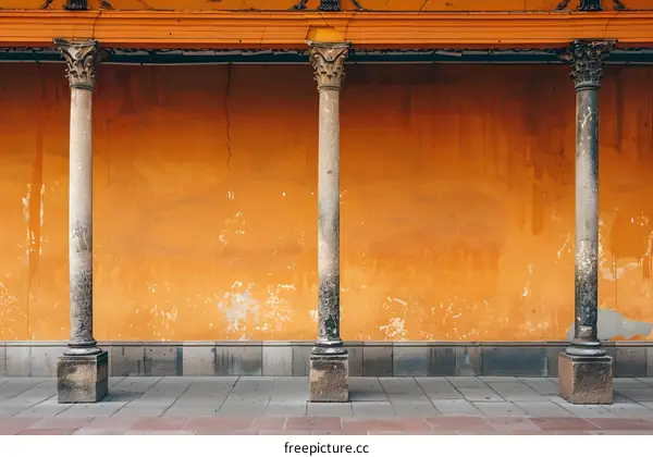 Stone Columns Against Orange Wall