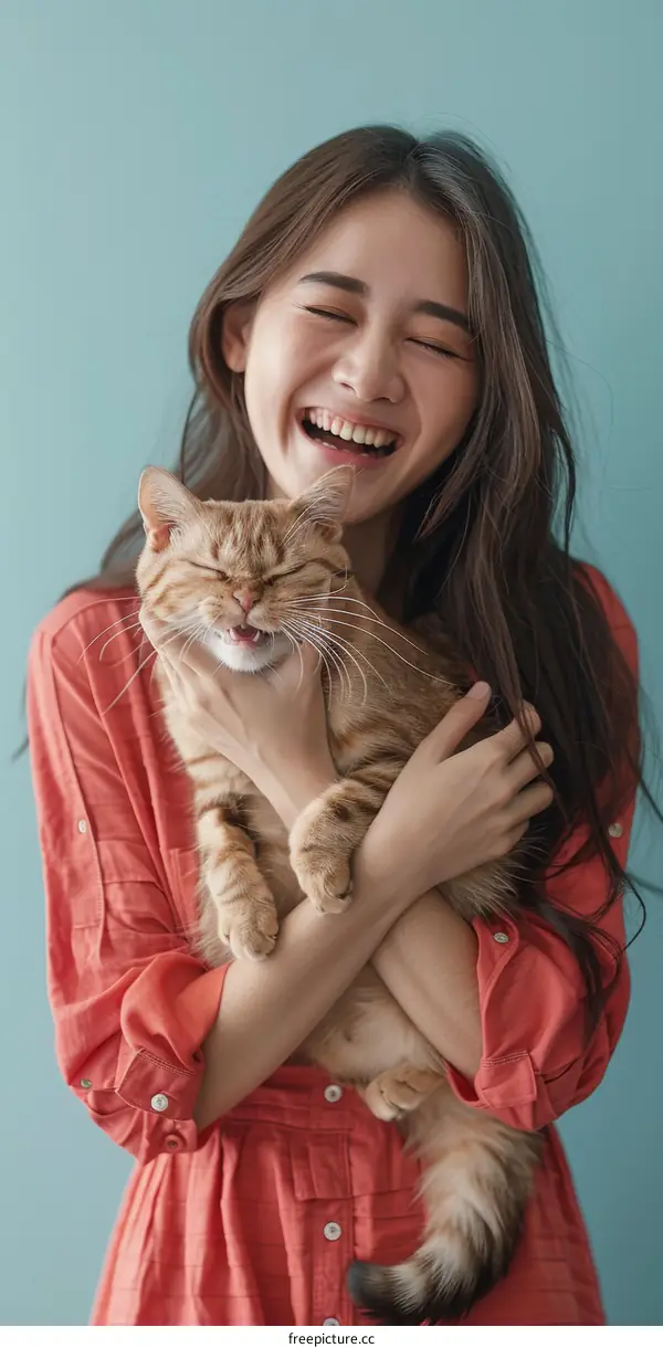 Laughing woman hugging an orange cat