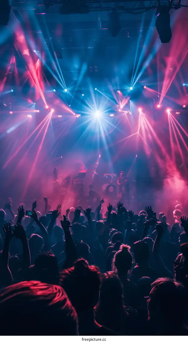 People dancing at a rave party with blue and red lights