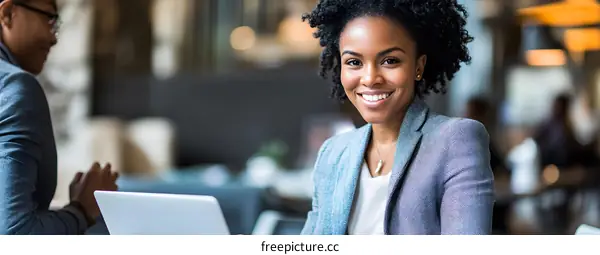 Smiling Businesswoman with Laptop Looking at Camera
