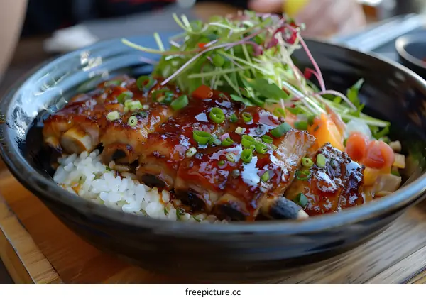 A delicious bowl of Japanese food with rice, pork ribs, and vegetables