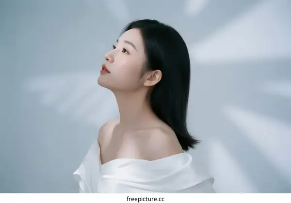A Young Woman with Straight Black Hair Wearing White Off-the-shoulder Dress