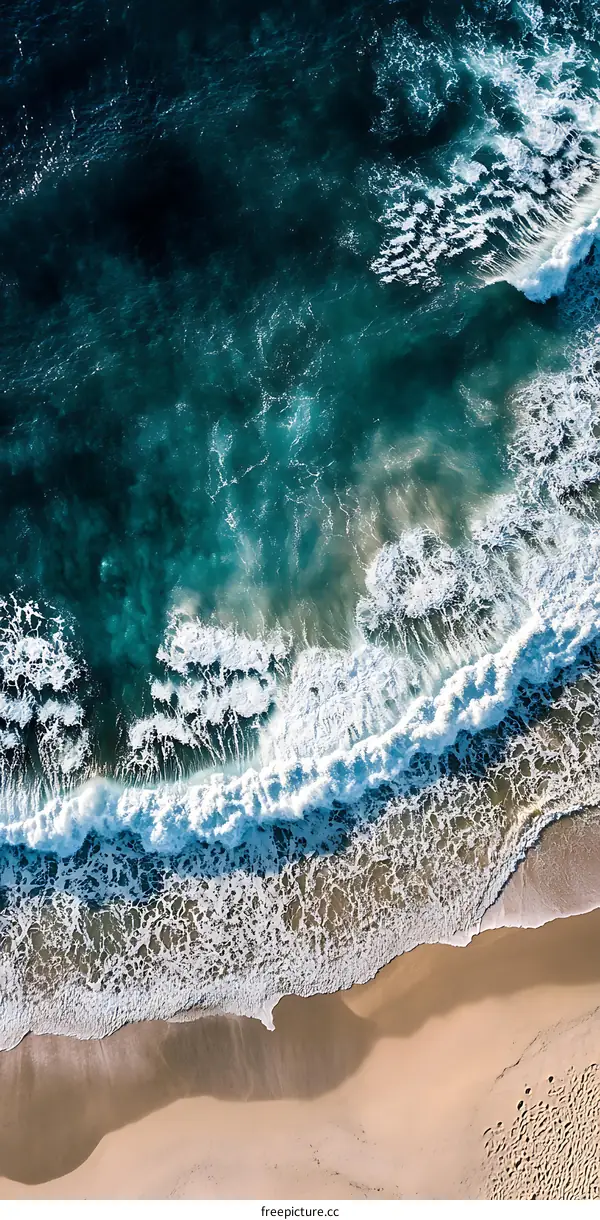 Aerial View of Ocean Waves Crashing on Sandy Beach