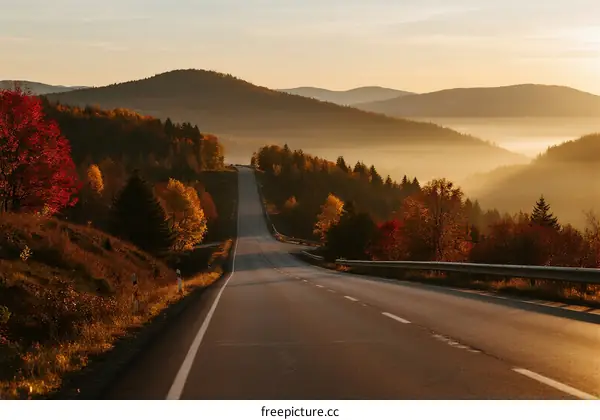 Scenic road through autumn mountains with misty atmosphere