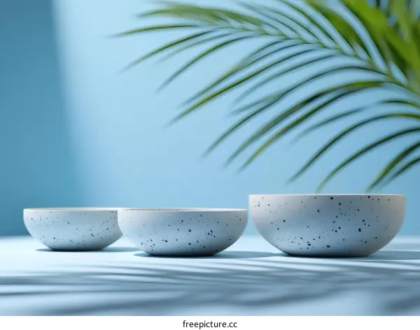 Three Light Gray Bowls on a Light Blue Background