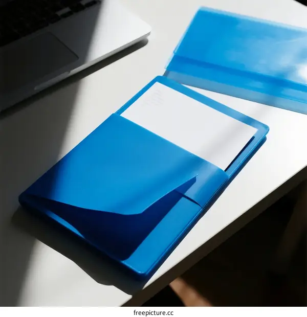 Blue Document Folder on White Office Table with Laptop