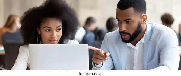 Two Business Professionals Working on Laptop Together in Office