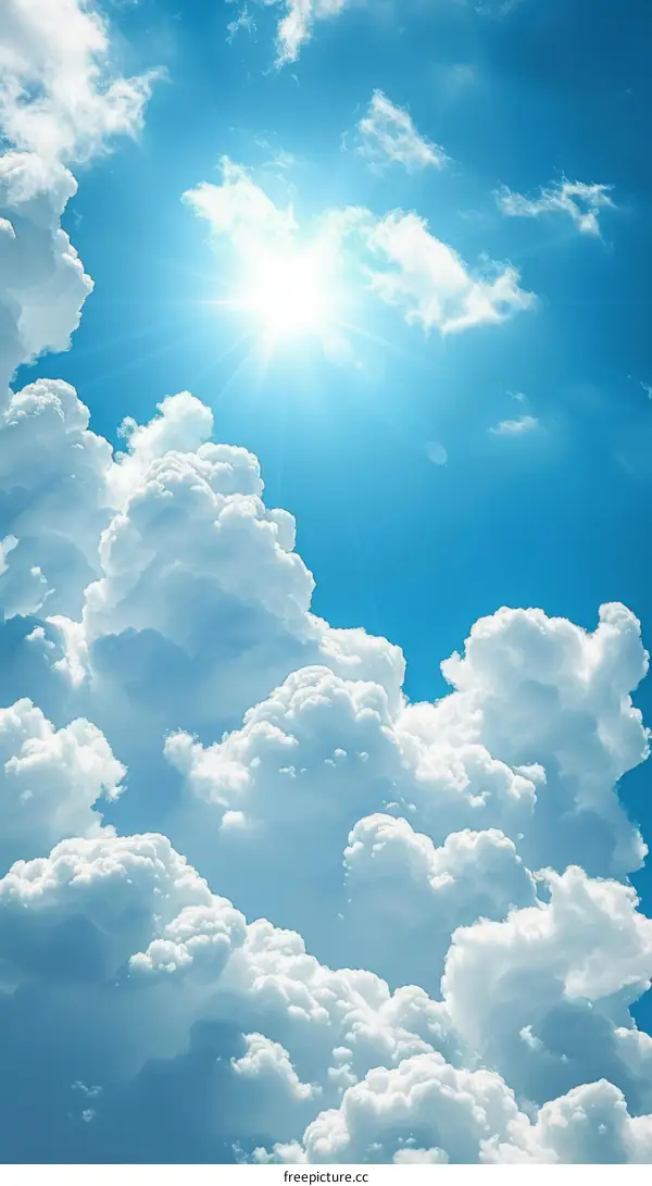 Blue sky and cloudscape with sun shining through fluffy clouds