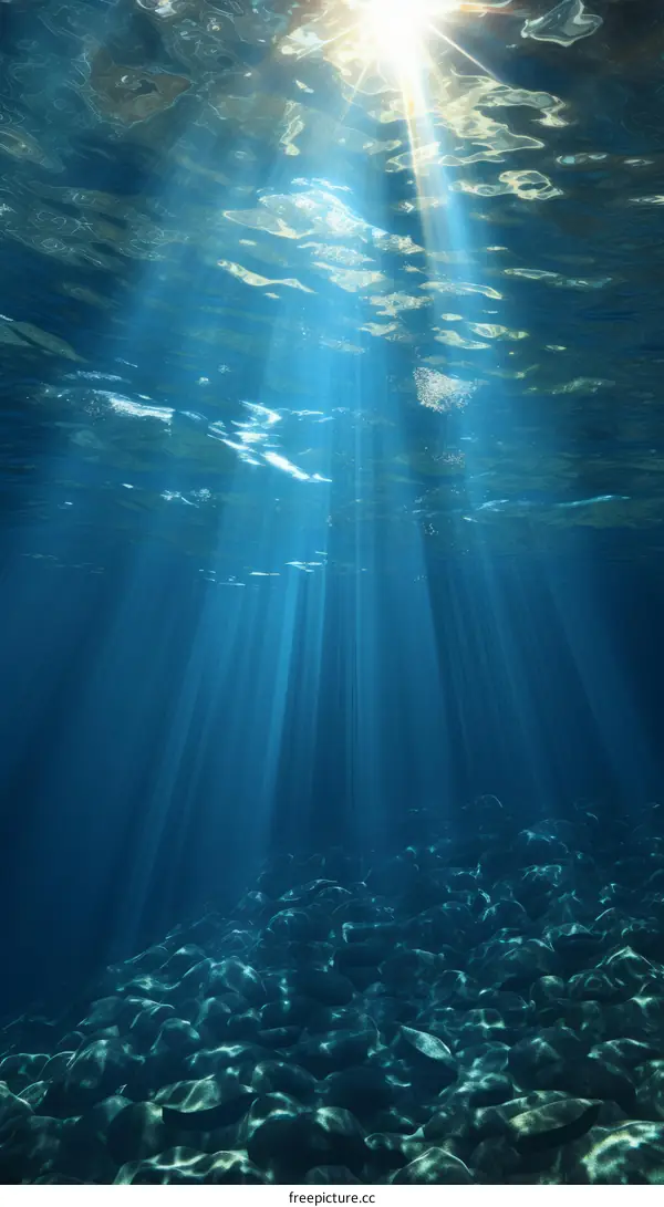 Underwater sunlight shining through the water surface and illuminating the rocky bottom