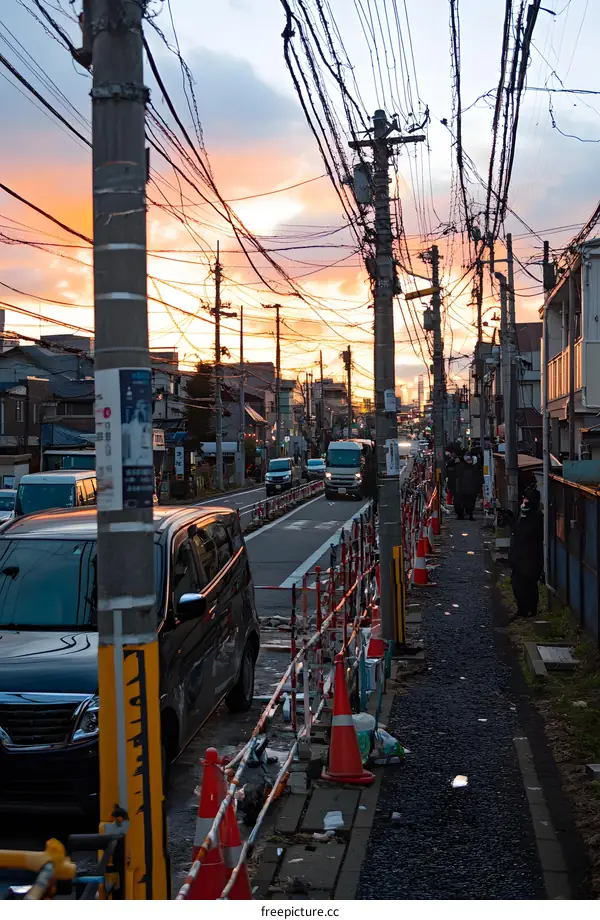 Sunset View of Japanese Street with Power Lines and People Walking