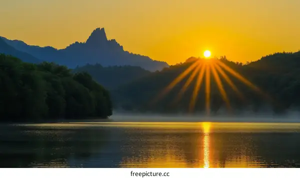 The setting sun shines on the lake and mountains