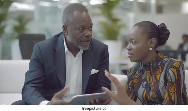 Confident business partners discussing work using a tablet