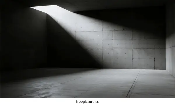 Minimalist concrete room with a single beam of light entering from above