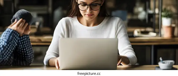 Woman Working On Laptop In Cafe
