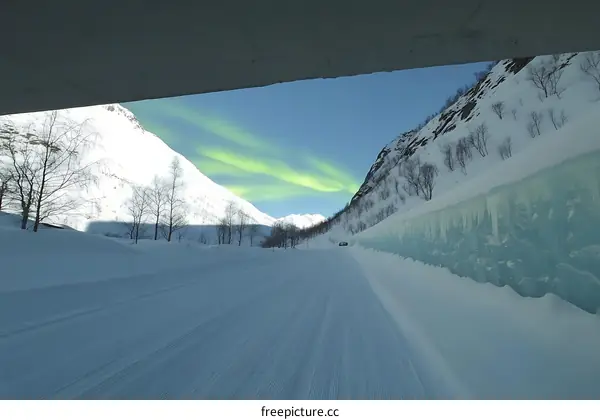 Snowy Road With Northern Lights In The Mountains