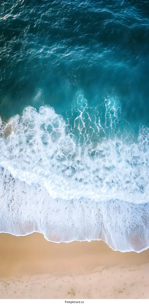 Aerial View of Ocean Waves Crashing on Sandy Beach