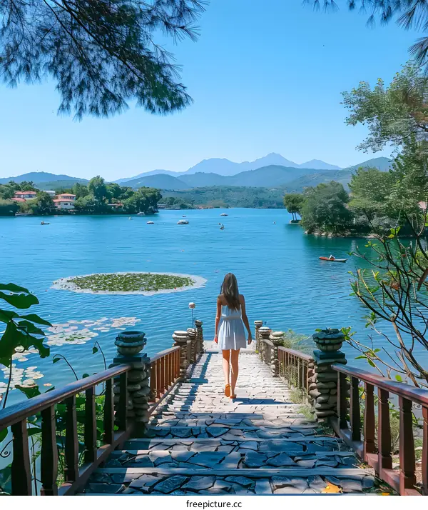 a girl is walking on a stone bridge over a lake with green island and mountain in the distance