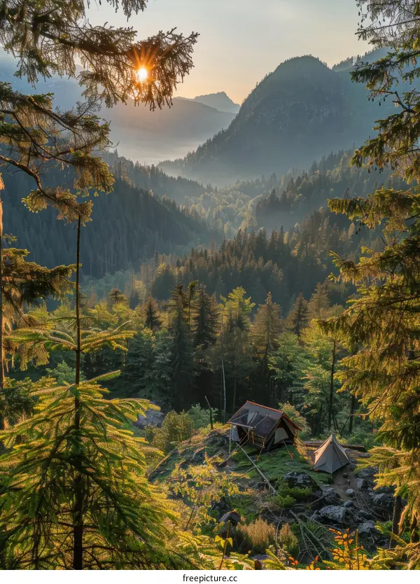 Two tents on a mountaintop overlooking a valley with a river and distant mountains