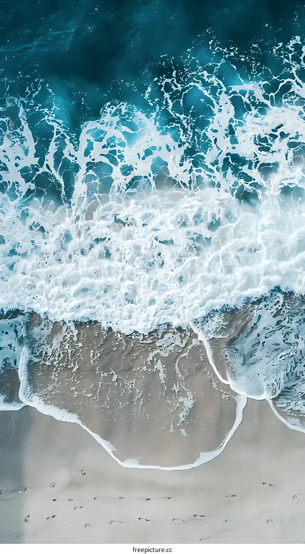 Aerial View of Foamy Ocean Waves Crashing on Sandy Beach