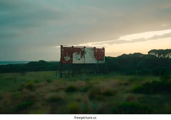Rusty Billboard in a Field Near the Ocean at Sunset