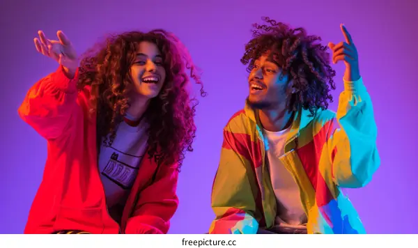 Portrait of two young people with curly hair smiling and laughing